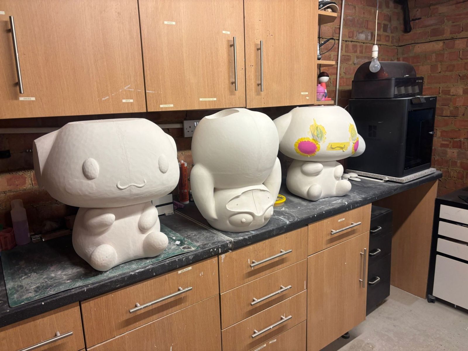Icyl workshop with three Cinnamoroll sculptures at different production stages on the workbench